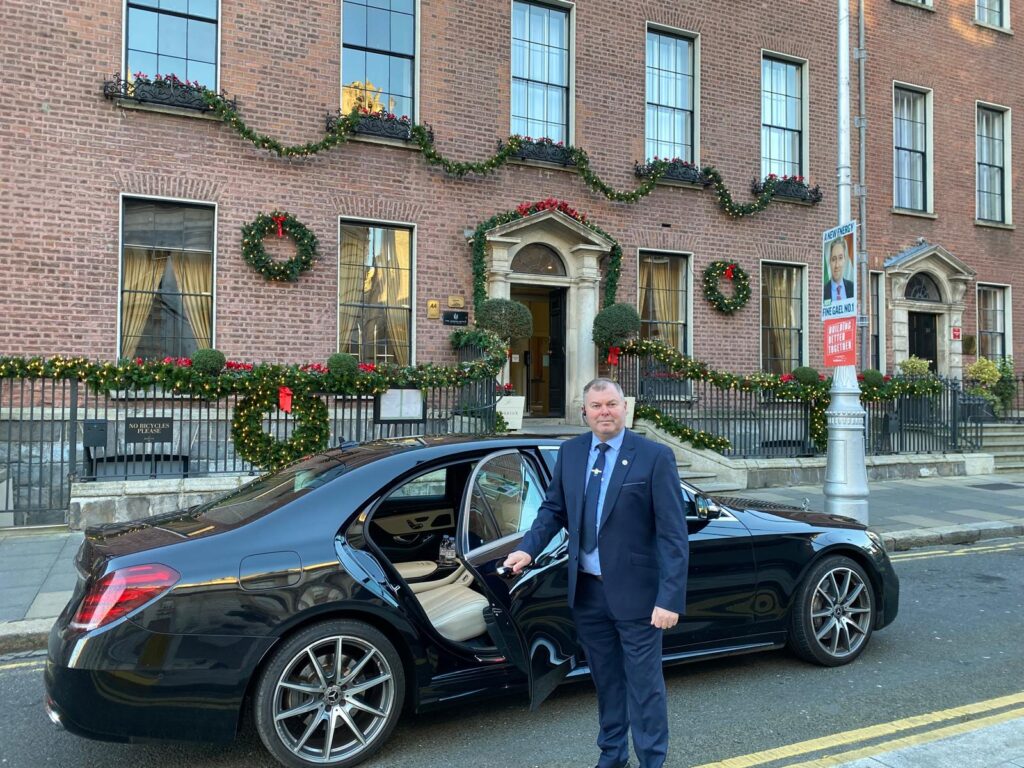 Alan McLoughlin, founder of Lir Executive Chauffeur Service, opening the car door for a client outside a Dublin hotel