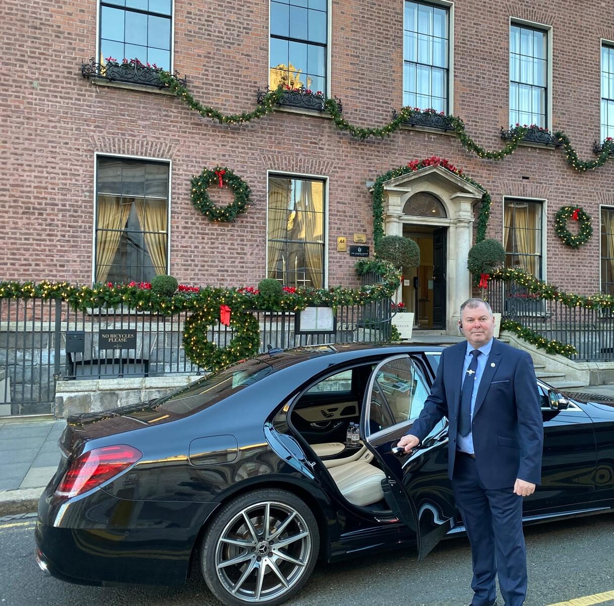 Executive chauffeur service in Dublin: Alan McLoughlin opening the car door outside a Dublin hotel