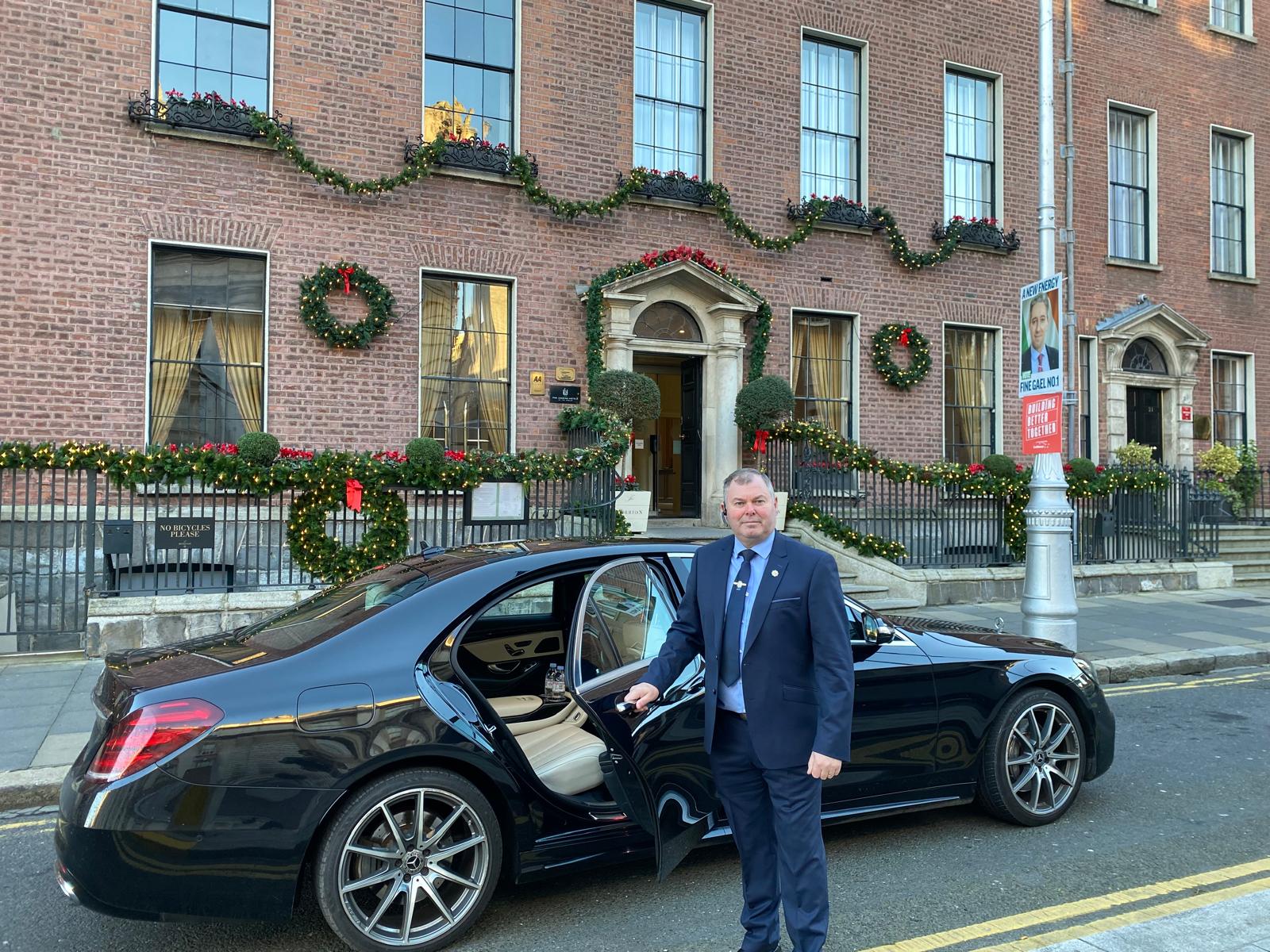 Alan McLoughlin, founder of Lir Executive Chauffeur Service, opening the car door for a client outside a Dublin hotel