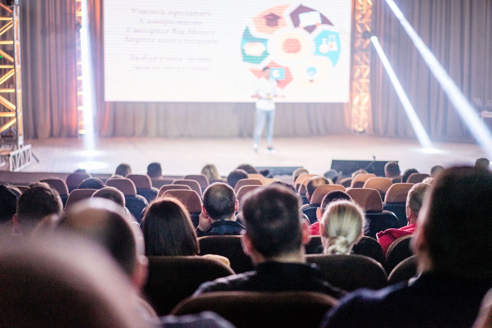 Delegates in a conference audience watching a keynote speaker on stage